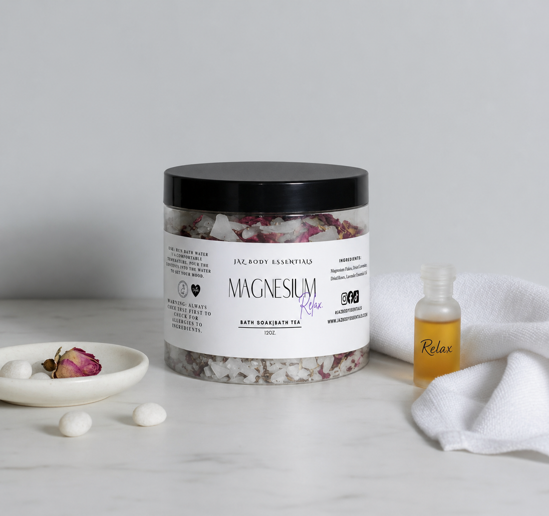 Magnesium Lavender Bath Soak jar styled with rose bud, essential oil bottle and white towel